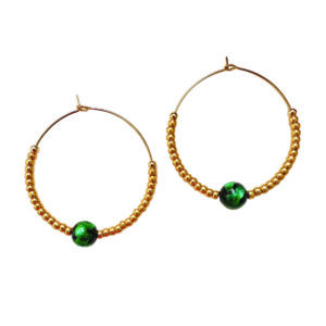 Ces créoles jouent sur la silhouette parfaite : cercle doré, touche verte vibrante, équilibre impeccable. Elles apportent ce détail mode qui fait toute la différence.