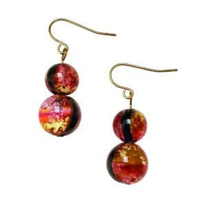 Deux lucioles suspendues à vos oreilles : l’une douce et ronde, l’autre plus discrète, brillant ensemble dans un souffle doré. Ces boucles d’oreilles Perséïdes laissent apparaître une lueur orangée qui s’anime au fil de la lumière, comme un fragment de ciel que l’on porte sur soi.