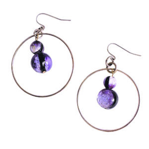 Graphiques et contemporaines, ces boucles d’oreilles jouent sur le contraste entre le minimalisme de l’anneau et l’intensité des perles violette-noir. Une pièce statement qui structure la silhouette et apporte une touche arty ultra-moderne.