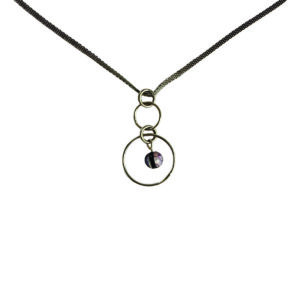 Épuré et contemporain, ce collier joue sur des volumes circulaires ultra-tendances et une touche de couleur violette. Une pièce chic et moderne qui complète facilement un look, du plus casual au plus sophistiqué.